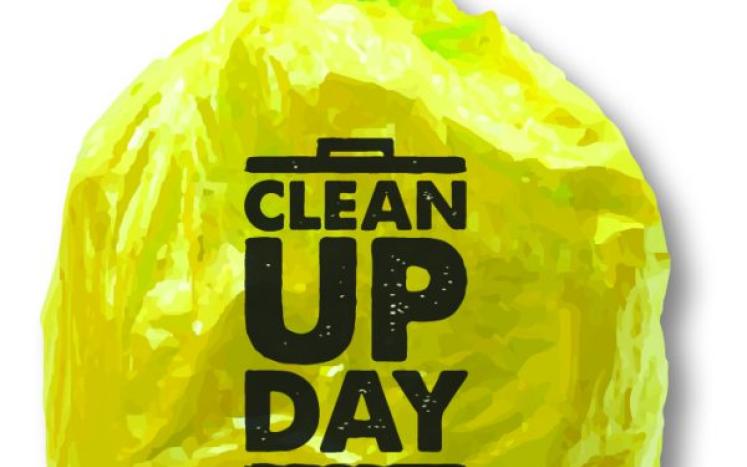 Yellow trash sack that says "Clean Up Day"